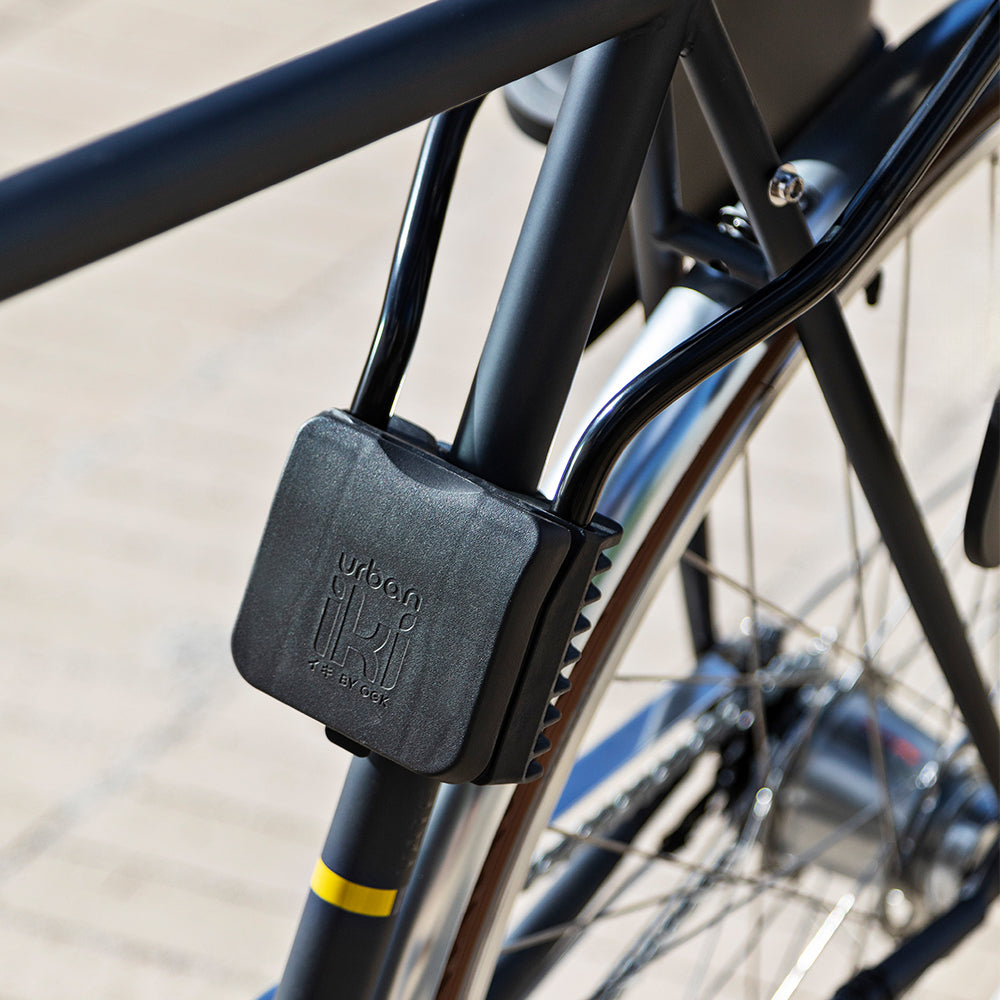 Urban Iki achterfietsstoeltje met framebevestiging, geschikt voor veilige achterzitjes op de fiets, in een stadsomgeving.
