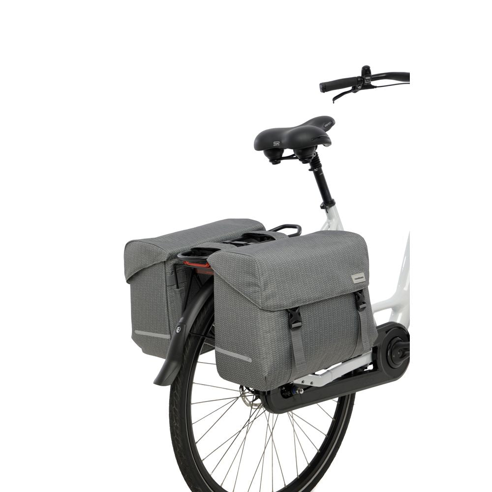 Dubbele fietstas van New Looxs Mondi Joy met 38 liter capaciteit, zwart en waterbestendig, bevestigd aan fietsdragers.