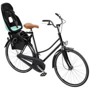 Fietsstoeltje Thule Yepp Nexxt 2 Maxi achterzitje bevestigd op fietsendrager, zwart kunststof met veiligheidsriemen.