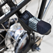 Inklapbare zwarte Urban Iki junior fietsvoetsteun voor fietsaccessoires, zichtbaar in een close-up afbeelding