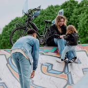Urban Iki achterzitje Ta-ke Easyfix voor fiets, bevestigd op de achterkant met stevig frame en veiligheidsriemen.