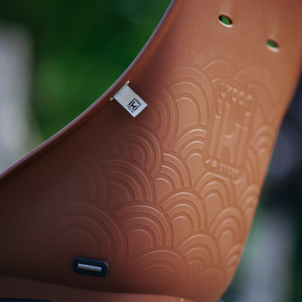 Urban Iki achterzitje Ta-ke BIO MIK HD op een fiets, zwart en comfortabel voor kinderen, bevestiging zichtbaar.