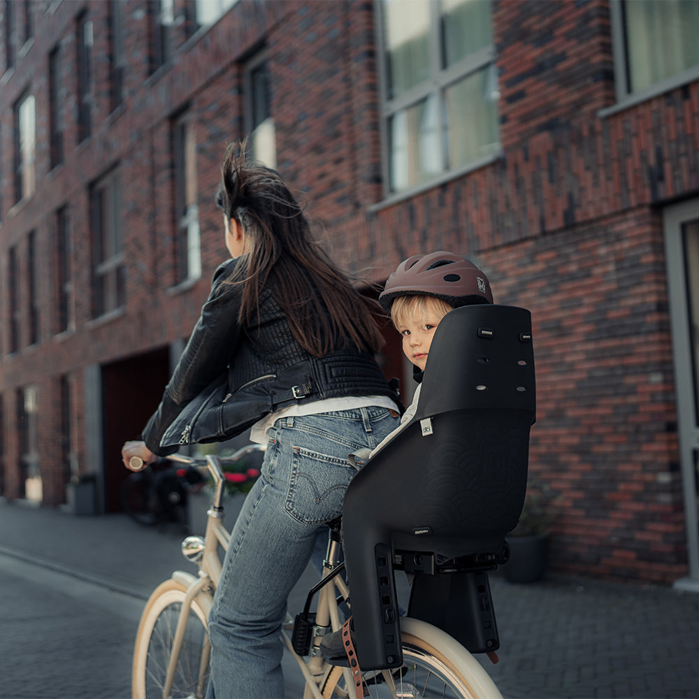 Urban Iki achterzitje U-me MIK HD op fiets, zwart kunststof met bevestigingsbeugel en veiligheidsriem voor kinderen.