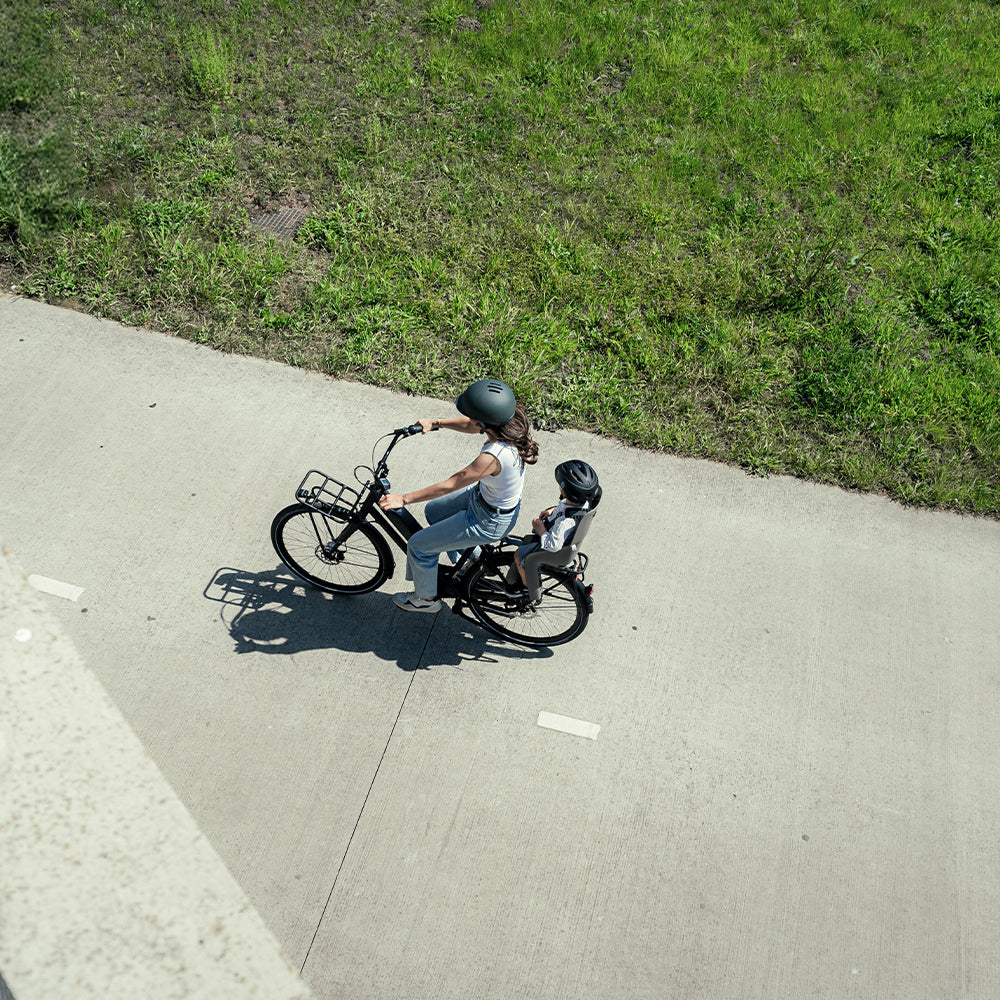 Urban Iki achterfietsstoeltje U-me MIK HD bevestigd op fiets, zwart kleur, geschikt voor kindertransport, veilig en comfortabel.