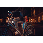 Zwart Axa Dwn USB-C oplaadbaar achterlicht met 1 lux helderheid, zichtbaar op de fiets in de afbeelding.