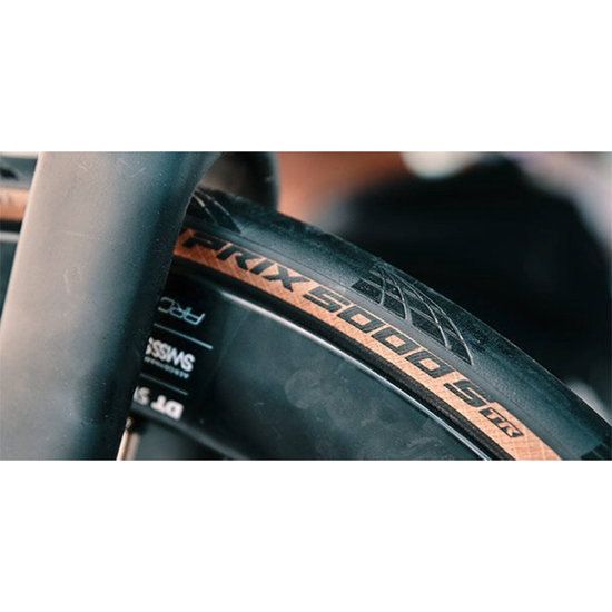 Continental Grand Prix 5000 S Racefiets band, tubeless ready, zwart met rode accenten, gelegd op een racefiets.