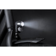Zwarte Axa Nox City 4 Lux koplamp met batterij, zichtbaar in de afbeelding, geschikt voor stadsfietsen.