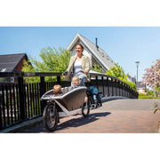 Steco Buggydrager Buggy-Mee Advanced Mat in zwart, zichtbaar bevestigd aan een kinderwagen voor extra bescherming.