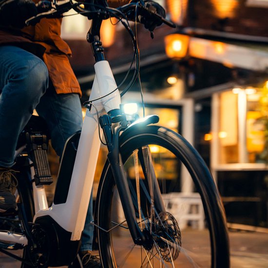 Axa NXT koplamp voor e-bike met geïntegreerde reflector en 6-12V compatibiliteit, zwart metalen behuizing en heldere lens