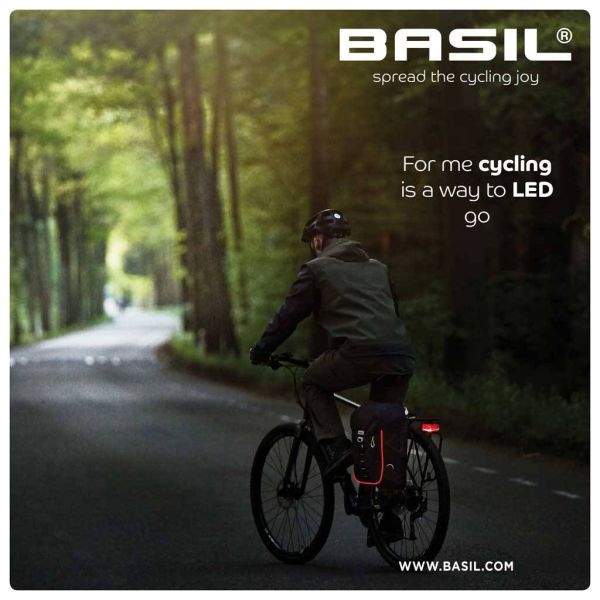 Basil fietsrugzak Miles Daypack Nordlicht, 17 liter, met verstelbare schouderbanden en reflecterende details, op een fietser gedragen