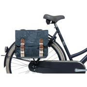 Basil Boheme 35 liter dubbele fietstas, waterdicht en stevig, bevestigd aan fietsmand met reflecterende details voor zichtbaarheid.