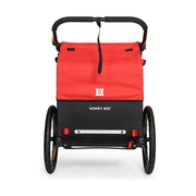 Burley Honey Bee kinderfietskar voor 2 kinderen, inklapbaar, rood en zwart, met comfortabele zitplaatsen en veiligheidsriemen.