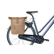 Basil Brooklyn 41 liter dubbele fietstas MIK, zwart met reflecterende details, bevestigd aan een fietsmand.