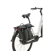 Zwarte New Looxs Cantos enkele fietstas met 16,5 liter inhoud, bevestigd aan een fiets, zichtbaar vanaf de zijkant.