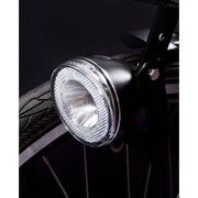 Zwarte Spanninga Swingo Xb LED koplamp met reflector en batterijen, ontworpen voor fietsverlichting.