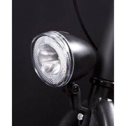 Zwarte Spanninga Swingo Xb LED koplamp met reflector en batterijen, geschikt voor fietsen, met heldere verlichting en reflectie.
