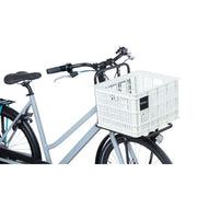 Basil fietskrat van 29,5 liter, gemaakt van gerecycled kunststof, geschikt voor fietsen, in een natuurlijke setting.