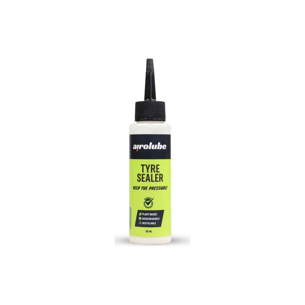 Biologisch afbreekbare Airolube bandenreparatieset met sealant voor autobanden, zichtbaar in de afbeelding met banden en gereedschap.