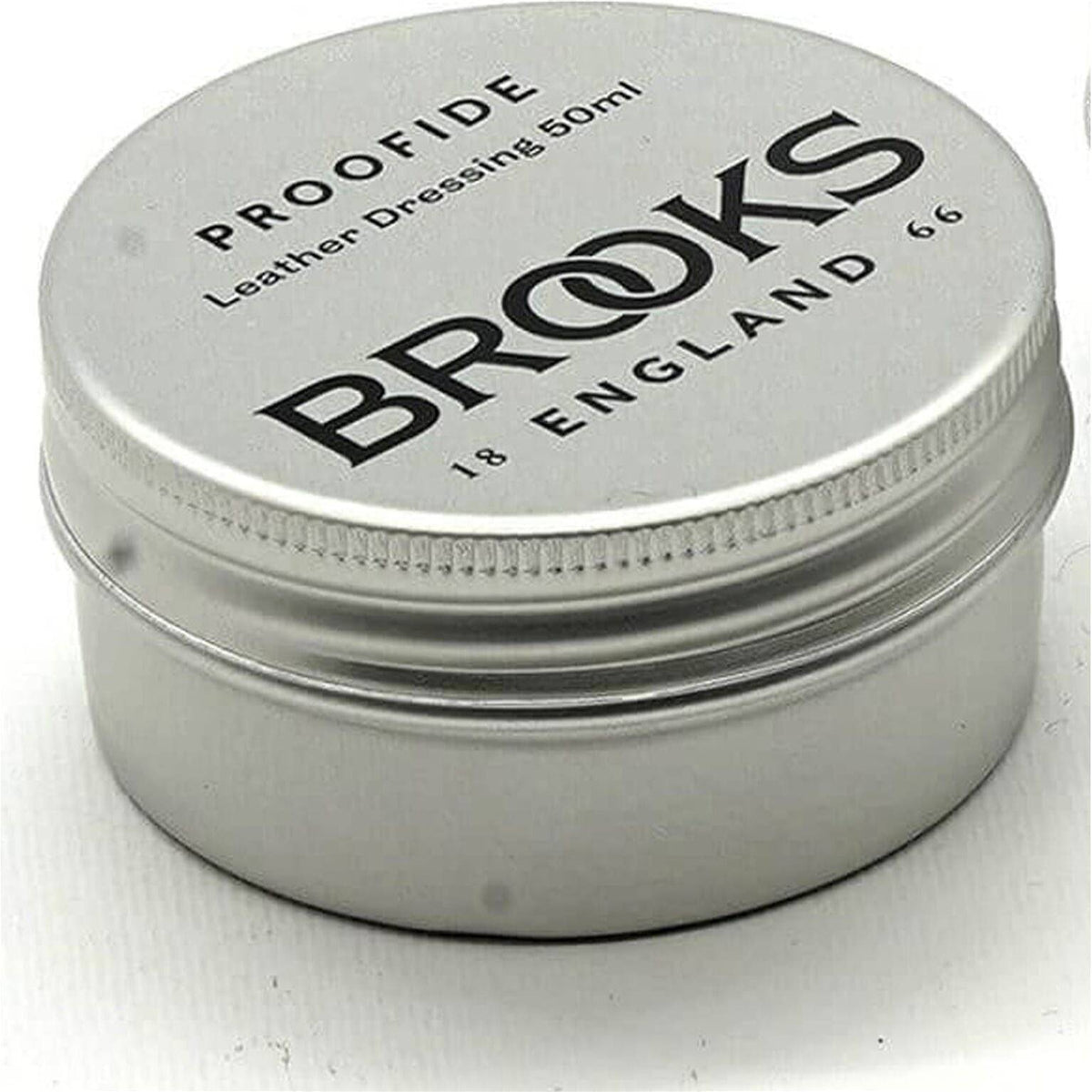 Brooks Zadelvet Proofide smeermiddel voor zadels, zichtbaar in een open pot met smeermiddel en een applicator.